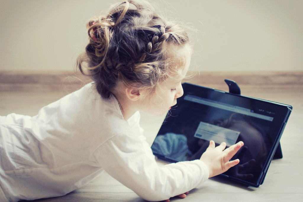 girl-playing-on-notebook-in-stand-on-floor