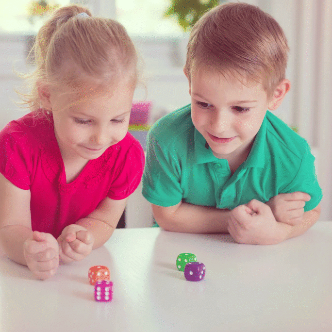 brother-and-sister-playing-with-dice-at-table