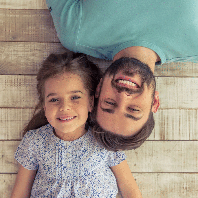 dad-daughter-lying-down-on-wood-planks