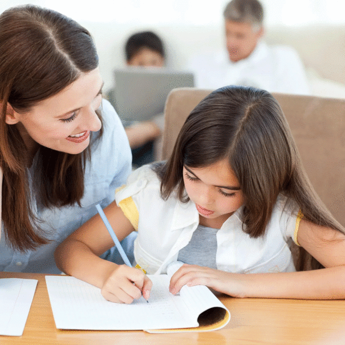 mom-and-daughter-homework-at-table-dad-and-boy-in-bg